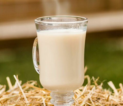 A glass cup of chai-tea on a straw bed