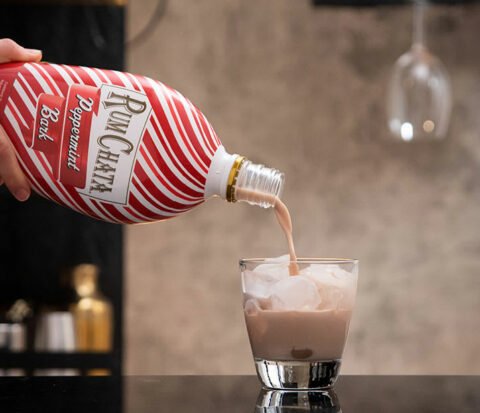 Rumchata peppermint bark bottle pouring into a glass with ice