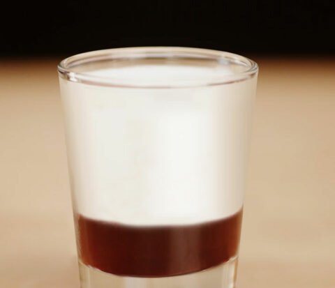 A two layered shot of rumchata jelly donut. Chilled rumchata on raspberry liqueur