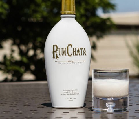 A glass of Rumchata on the rocks and a bottle of Rumchata