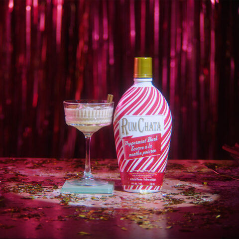 A glass of holiday Alexander beside a Rumchata peppermint bark bottle.